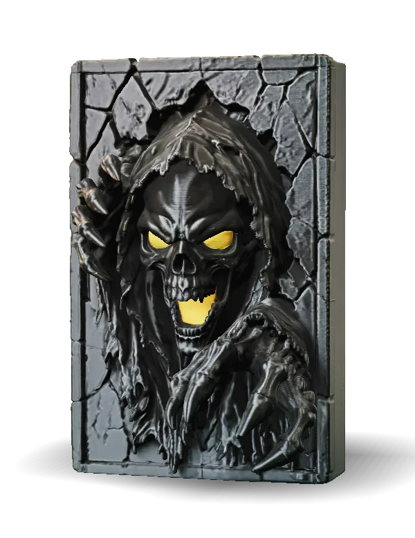 Dark fantasy relief sculpture of a hooded skeletal reaper emerging through a cracked rectangular stone frame. The glossy black figure has glowing yellow eyes and mouth, a snarling skull, tattered robes, and oversized clawed hands reaching forward. Shown in a front three-quarter view with gray stone textures and metallic highlights.